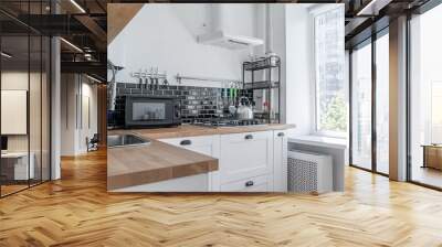 black and white kitchen. Kitchen with appliances, microwave, oven. wooden countertop in the kitchen. Metal sink, colorful glasses, mugs, knives. Wall mural