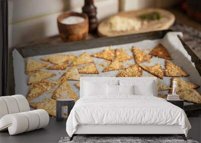 Process of cooking cheese Tortilla chips with olive oil on baking sheet before oven, homemade salty savory pastry snack in the kitchen. Selective focus with copy space. Wall mural