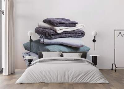 Pile of clean folded home textile items near the white wall. Wall mural