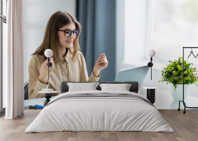 Business woman has video call with her remote team using laptop and camera Wall mural