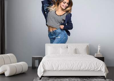 Full length portrait of a joyful young woman jumping and celebrating over gray background Wall mural