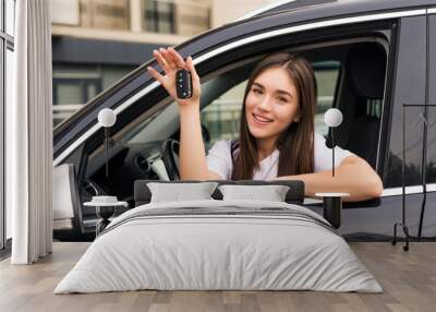 Happy young smiling woman with new car key Wall mural