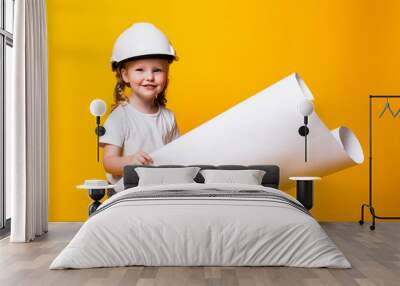 Little girl architect in the construction helmet with a poster isolated on yellow background Wall mural