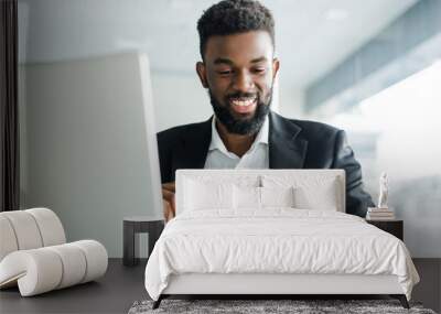 Young african american business man using phone and making winner gesture with fist in office Wall mural