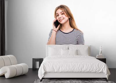 Young happy caucasian teen girl is calling with a mobile phone isolated on white Wall mural