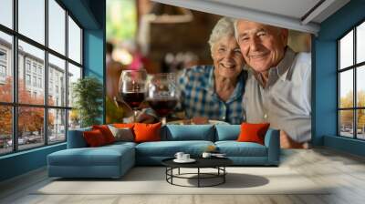 Happy senior friends having fun cheering with red wine at barbecue in terrace outdoor - Mature people making dinner toasting glasses and laughing together - Friendship and elderly lifestyle concept Wall mural