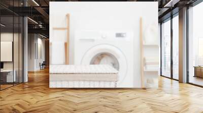 White closed basket in front of blurred laundry room interior background with washing machine and storage shelves Wall mural