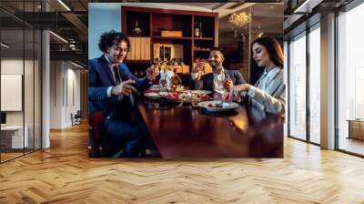 Classy business people enjoying themselves while having dinner Wall mural