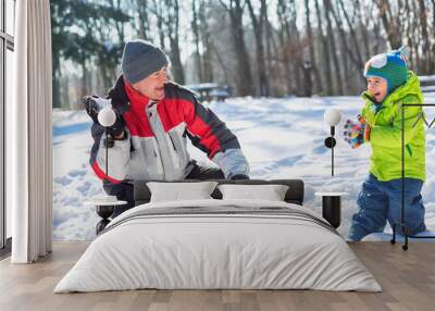 Grandfather throwing snowballs with his grandson Wall mural