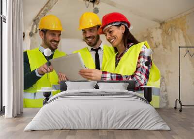 Group of young arhitects with l tablet on construction site Wall mural