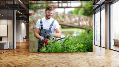 Handsome man dressed in gardening outfit Wall mural