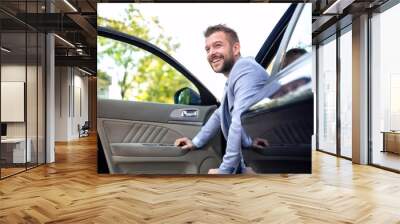 Smiling man exiting his vehicle Wall mural