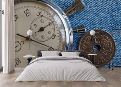 Denmark coin with a denomination of two crown (krone) (back side) and stopwatch on worn blue jeans backdrop - business background Wall mural