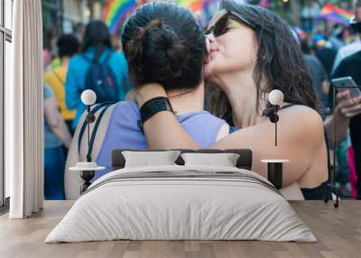 A girl giving a kiss in the cheek to another girl in the Buenos Aires gay parade - Argentina Wall mural