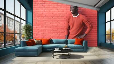 African Young Man Smiling And Leaning On Red Wall Wall mural