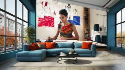 hispanic woman doing budget in fashion designer atelier Wall mural