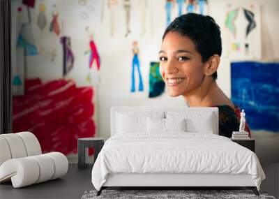 Portrait of happy hispanic young woman working as fashion design Wall mural