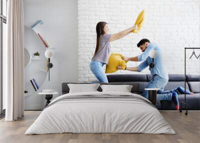 portrait of young couple playing pillow fight Wall mural