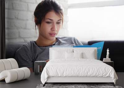 Woman Reading Travel Flye On Sofa At Home Wall mural