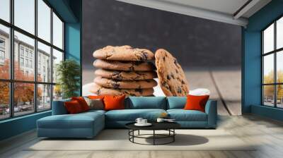 chocolate chip cookies on wooden table, stack of chocolate chip cookies on a wooden table, chocolate chip cookies on top of white dish towel on a white wooden table Wall mural