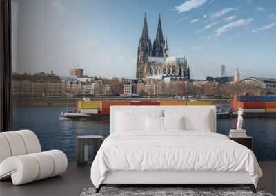 Cargo ship transporting containers on the Rhine River with Cologne Cathedral on background - Cologne, Germany Wall mural