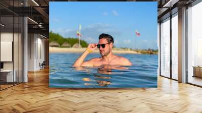 Hispanic young man posing in a tropical beach in Baru Island, Cartagena de Indias, Colombia Wall mural