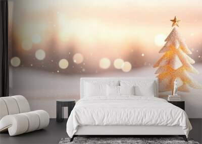 A glittery gold Christmas tree with a golden star stands in a snowy field, illuminated by a warm, soft glow from blurred lights in the background. Wall mural