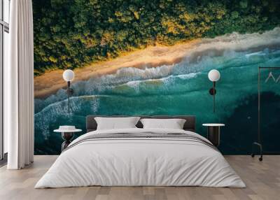 Aerial view of a serene beach with crystal-clear turquoise waters and lush green forest. Perfect for nature, travel, and tropical getaway concepts. Wall mural