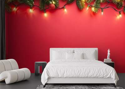 Festive Christmas garland with glowing lights and a red bauble on a red background, perfect for holiday decorations. Wall mural