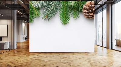 Snow-dusted pine branches and frosted pinecones arranged against a white background for a fresh winter display. Wall mural