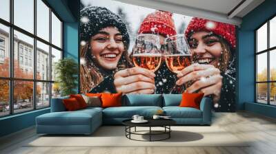 Three friends toasting with glasses of wine outdoors, smiling in the snow. Wall mural