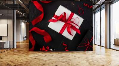 White gift box with a red ribbon on a black background. Stylish and festive design perfect for holiday gift presentations. Wall mural