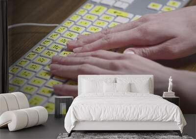 Close-up of a computer keyboard with braille. A blind girl is typing words on the buttons with her hands. Technological device for visually impaired people Wall mural