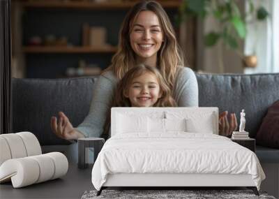 Cute little girl with young mother sitting in lotus pose on couch at home, mum and daughter practicing yoga and laughing, having fun on weekend, Generative AI Wall mural