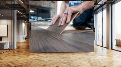 man installing engineered laminate wood floring indoor Wall mural