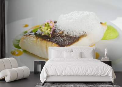 Baked turbot fillet on a white plate. Delicious fish meal with herbs and served with pea puree. Studio shot. Wall mural