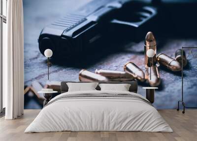 Hand gun with ammunition on dark background. 9 mm pistol military weapon and pile of bullets ammo at the metal table. Wall mural