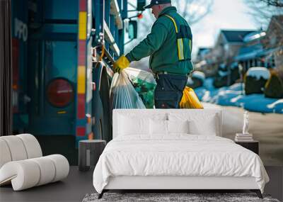 a person in work attire loading bags into the back of a garbage truck on a sunny day Wall mural