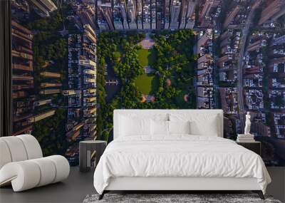 an aerial view of Central Park in New York City. The park’s lush greenery stands out against the surrounding urban skyline filled with tall buildings Wall mural