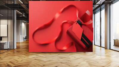 A vibrant red gift box with a ribbon and tag, perfect for celebrations, holidays, and special occasions. Wall mural