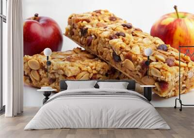 Freshly baked granola bars loaded with crunchy apple pieces and sweet raisins, sit isolated on a clean white background, exuding warmth and wholesome goodness. Wall mural