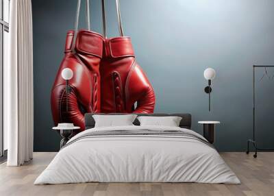 Red boxing gloves hang from a Rope on a solid colored background, providing ample copy space for text or logos, evoking a strong fighting spirit theme. Wall mural