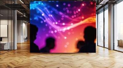 Silhouettes of people against a vibrant, colorful background filled with abstract lights and waves, creating a festive atmosphere. Wall mural