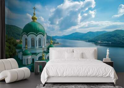 A beautiful, green-domed monastery sits peacefully beside a clear, tranquil lake, surrounded by lush, rolling hills and a picturesque sky, depicting a serene and historical scene. Wall mural