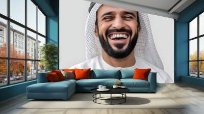 Close-up of a joyful Middle Eastern man wearing traditional attire, showcasing a genuine smile and positive emotion, with gray background. Wall mural