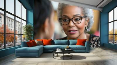 Mentorship in Action: Mature Woman Offering Guidance to Young Colleague in Private Office, Embracing Supportive Leadership and Development Wall mural