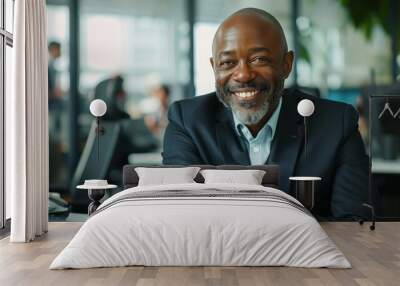 African American businessman smiling at camera while sitting in a modern office Wall mural