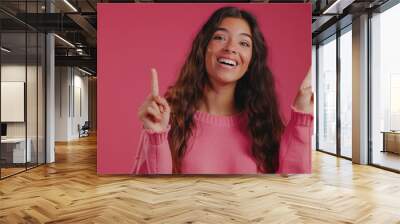 Portrait of beautiful young Hispanic or Latinx woman wearing a pink sweater showing two peace signs with fingers on magenta background, template for advertising or promotion, with copy space for text Wall mural