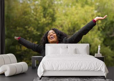 African American woman smiling with open arms. Wall mural