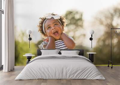 Happy little girl laughing and smiling outside. Wall mural